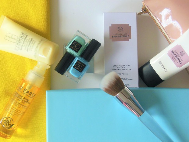 Beauty flatlay featuring tubes, bottles and brush